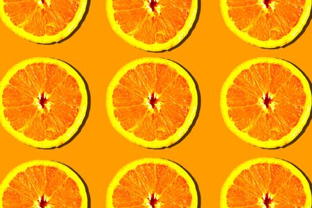 Sliced oranges pattern on bright orange background, minimal conceptの写真素材