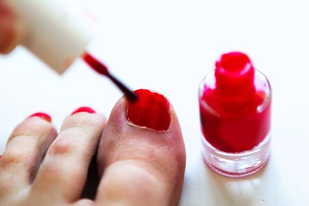 Woman paints her toenails red polish, closeupの写真素材