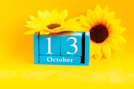 October 13. Wooden cube calendar with month and date on bright orange backgroundの写真素材