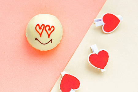 Tasty sweet cake with draw face and heart eyes on geometric pastel pink and yellow  background, top...