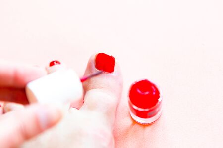 Woman paints her toenails red polish, closeupの写真素材