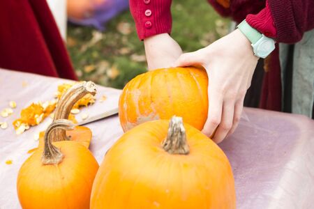 woman is carving pumpkin in the park. Halloween conceptの写真素材