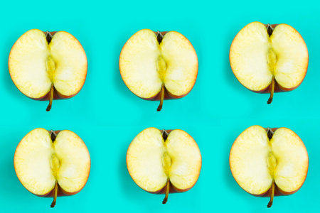 Sliced apple pattern on blue background, minimal concept