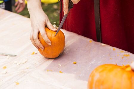 people are carving pumpkin head in the parkの写真素材