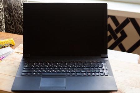 Laptop with black mockup screen on the table