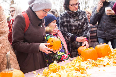 Minsk/ Belarus  - October 31 2019: people are carving head pumpkin in the parkのeditorial素材
