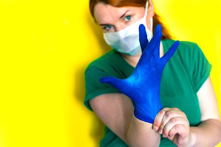 girl in a medical mask puts on gloves, covid-19 conceptの写真素材