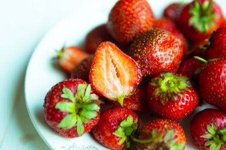 Fresh tasty strawberry on white plate, top viewの写真素材