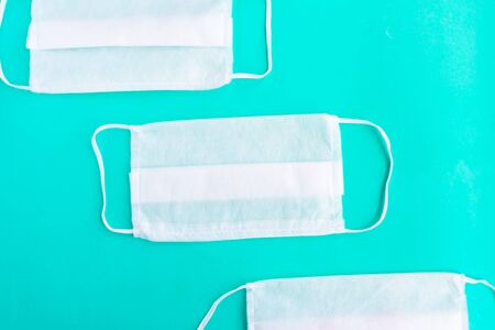 Medical masks on green mint background, covid-19 conceptの写真素材