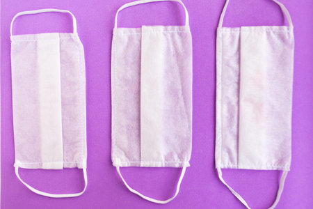 Medical masks on purple background, covid-19 concept
