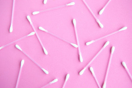 Cotton buds pattern on pink pastel background, top view