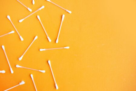 Cotton buds pattern on orange background, top view, copy spaceの写真素材