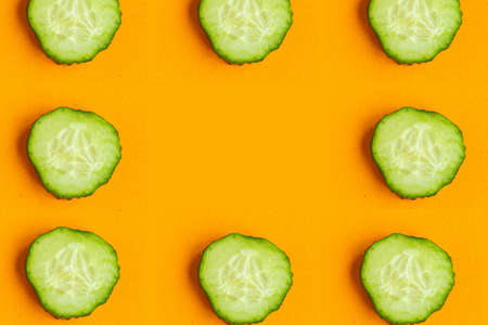 Cucumber pattern on bright orange background, minimal concept, copy space for the textの写真素材