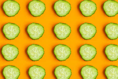 Cucumber pattern on orange background, minimal conceptの写真素材