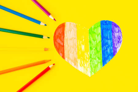 Heart in lgbtq colors and pencils on bright yellow background, top viewの写真素材