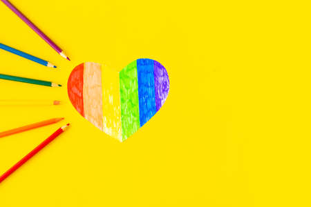Heart in lgbtq colors and pencils on bright yellow background, top view, copy spaceの写真素材