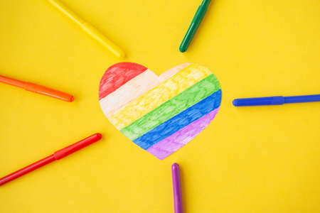 Heart in lgbtq colors and pencils on bright yellow background, top viewの写真素材