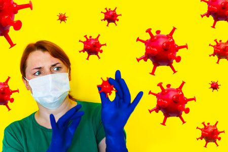 girl in medical mask holds red bacteria in her hands, covid-19 concept