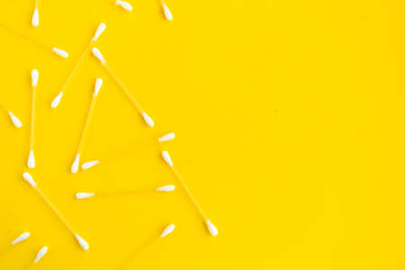 Cotton buds pattern on yellow background, top view, copy spaceの写真素材