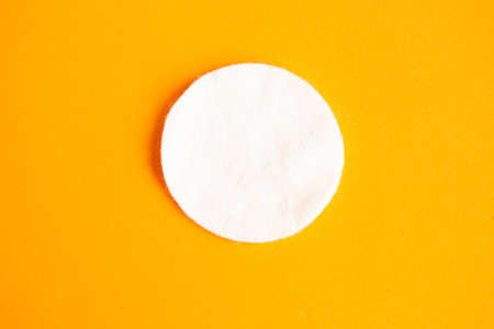 Cotton sponge on bright orange background, top viewの写真素材