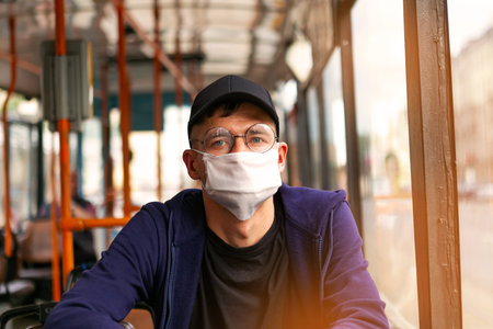 Man in protective medical mask in bus. Public transport during coronavirus covid-19 pandemic