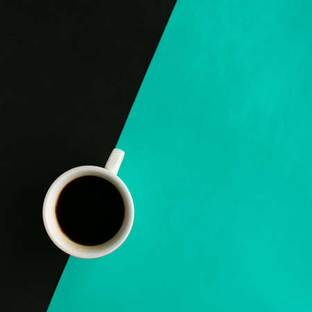 Coffee cup on geometric black and green background, top view, copy space for the text, minimal conceptの写真素材