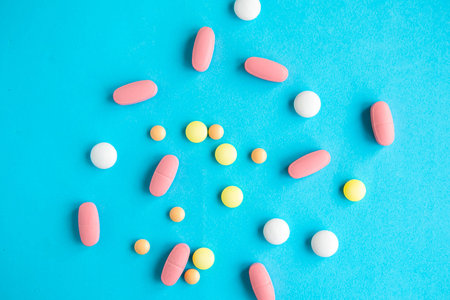 Medical pills on bright blue background, top view