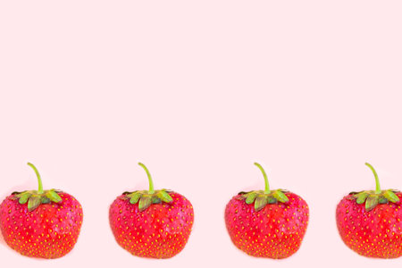 Strawberry pattern on pastel pink background, copy space for the textの写真素材