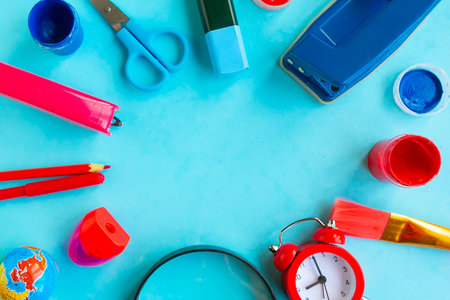 School supplies on blue background, top view, copy space