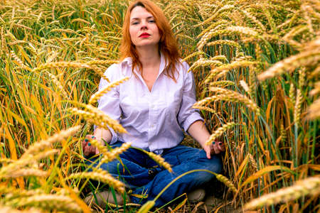 Redhead lady in wheat field, summer backgroundの写真素材