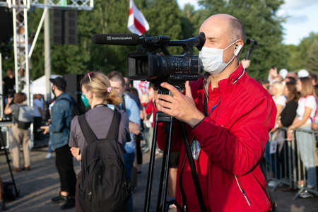 Minsk / Belarus - 30 July 2020: videographer in a medical mask works with a camera in the parkのeditorial素材