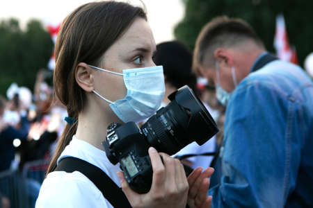 Minsk / Belarus - July 30, 2020: portrait of young girl in face mask with cameraのeditorial素材