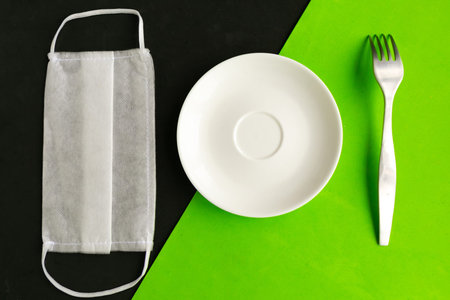 medical mask and empty plate on color background. Minimal concept. Covid-19 concept