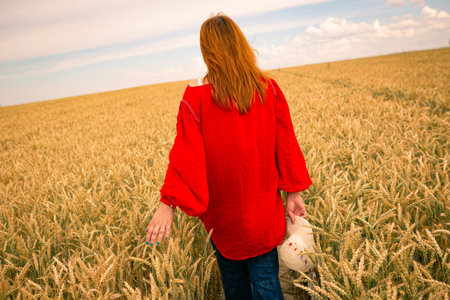young girl in a wheat field, view from the back