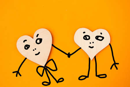 Two hearts with draw faces on orange background - lgbt conceptの写真素材