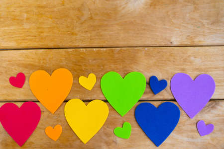 Hearts in lgbtq colors on wooden background, top view, copy spaceの写真素材