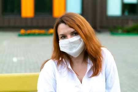 Portrait of redhead girl in medical mask, closeupの写真素材