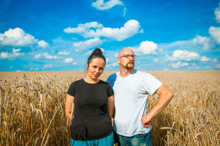 Young woman and man in a wheat field, summer backgroundの写真素材