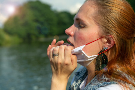 Woman taking off protective mask from her face, corona free concept