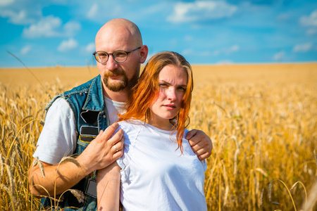 Young woman and man in a wheat field, summer background