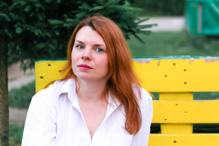 Portrait of redhead girl in the park, closeup