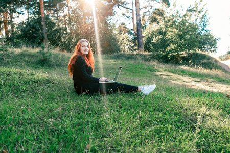Freelancer in the nature. Woman is working on laptop in forest.の写真素材