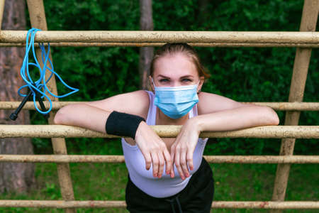 Woman wearing surgical mask doing training in the forest, coronavirus conceptの写真素材