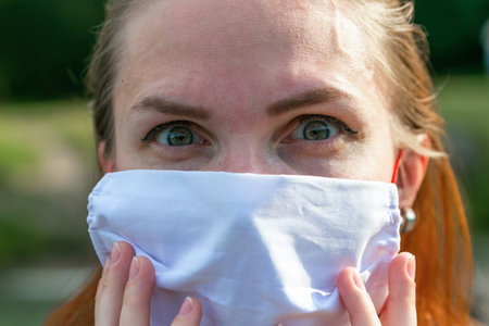 Portrait of redhead girl in surgical mask, coronavirus concept