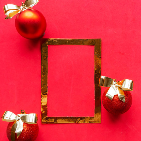 Golden frame and baubles on red background. Template for Christmas greeting cardの写真素材