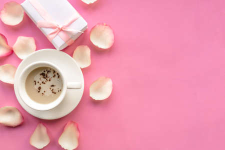 Coffee cup and gift box on pink background, top viewの写真素材