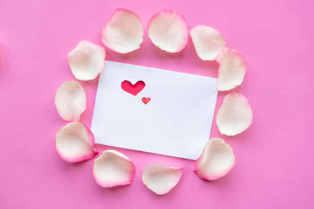 Valentine mockup greeting card and rose petals on pink background, top viewの写真素材