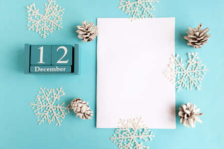 December 12. Blue cube calendar with month and date and white mockup blank on blue background.の写真素材