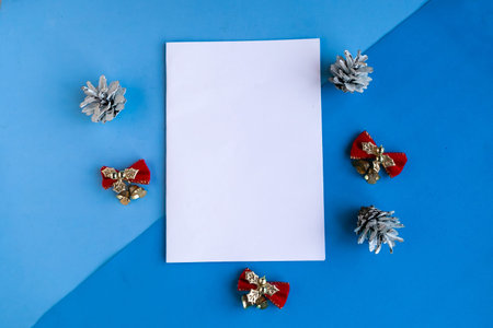 White mockup blank and Christmas decorations on color background. Copy space for the text. Template...