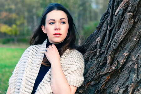 Portrait of a thoughtful girl in autumn park, fall background